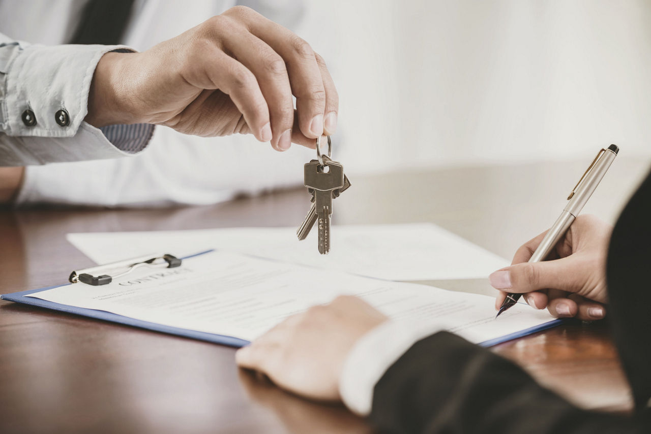 Woman is handing a gentleman keys | Blog | Greystar